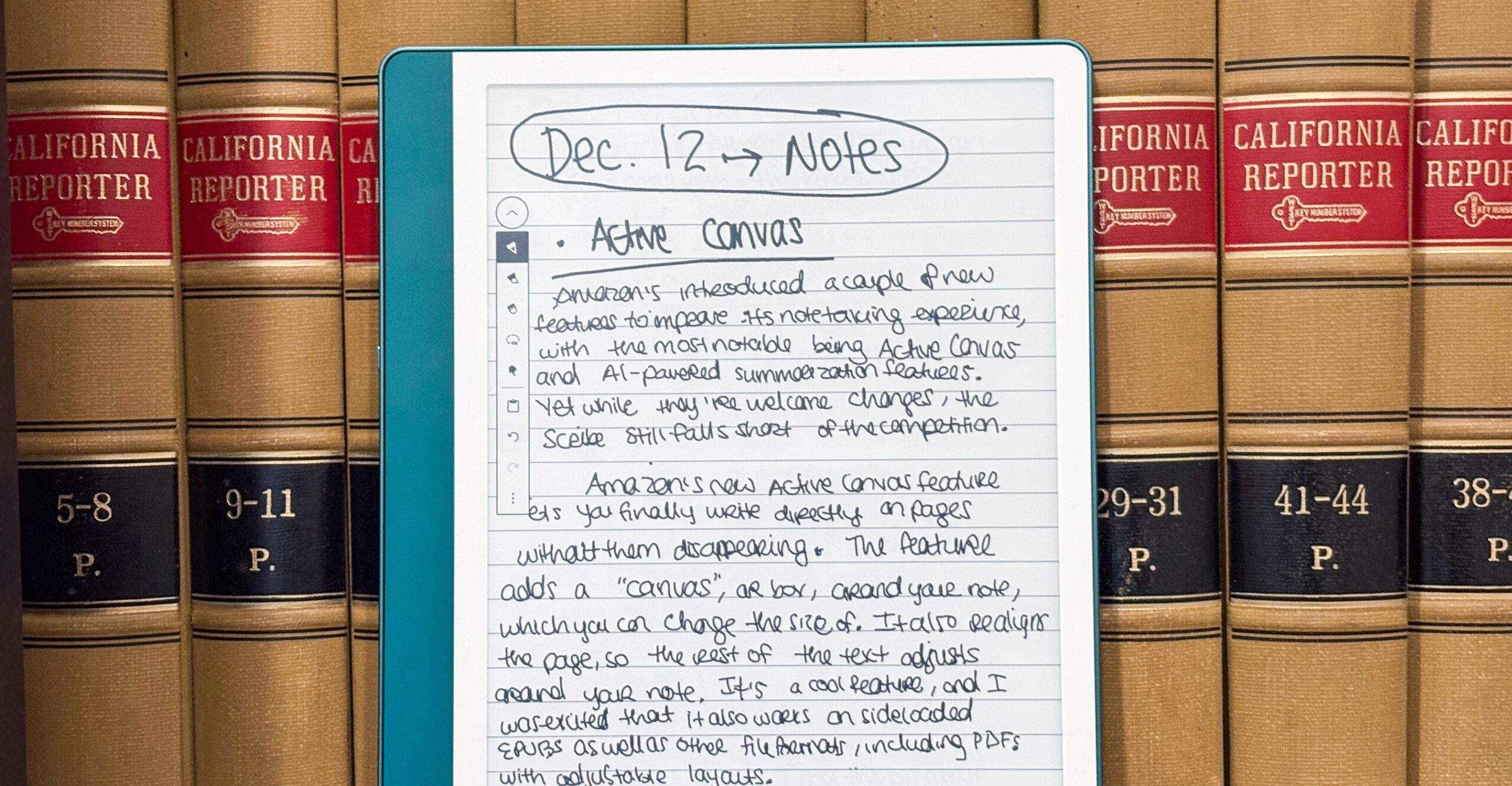 The Kindle Scribe sitting on a bookshelf, with its display featuring my handwritten notes.