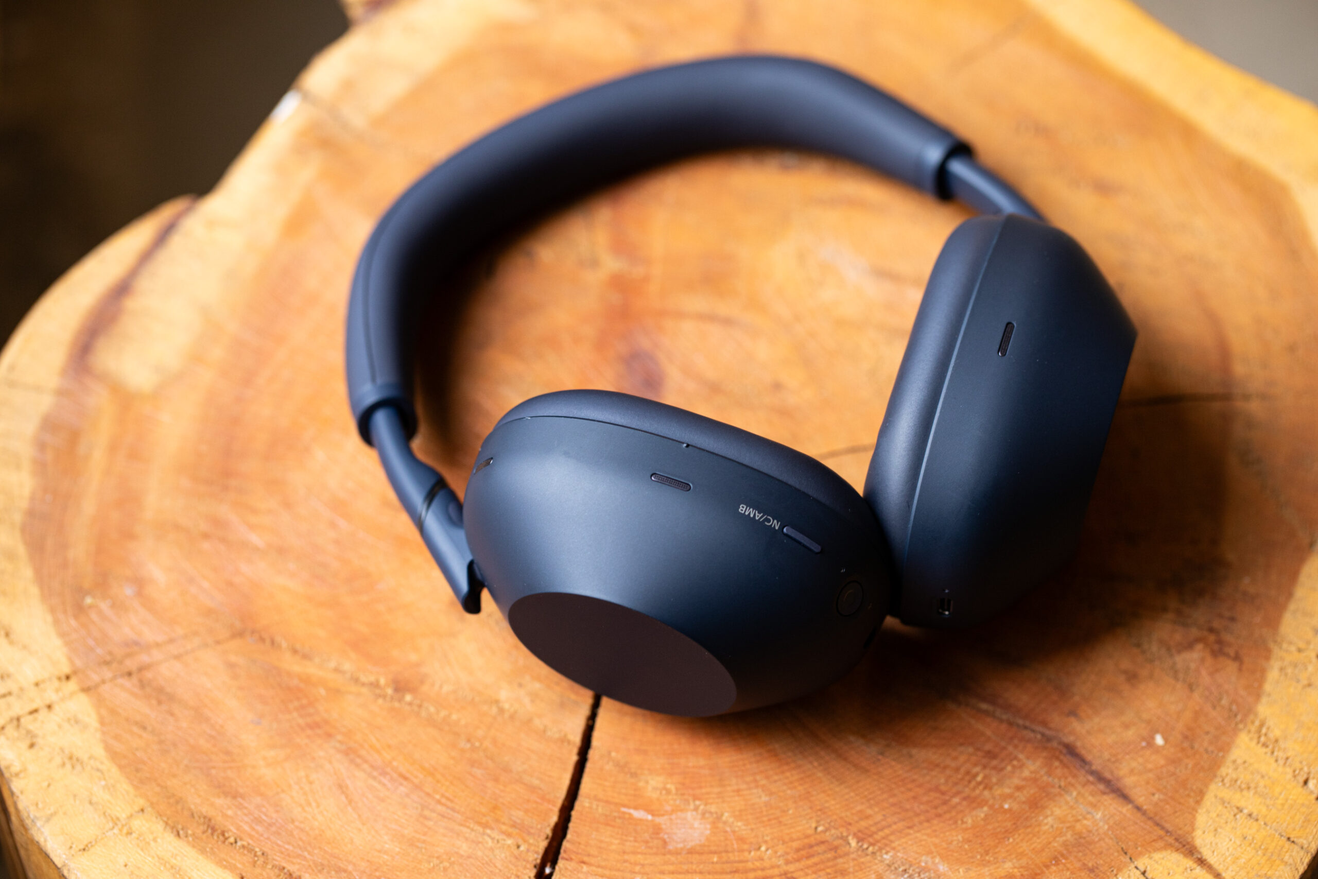A pair of black headphones on a stump. 