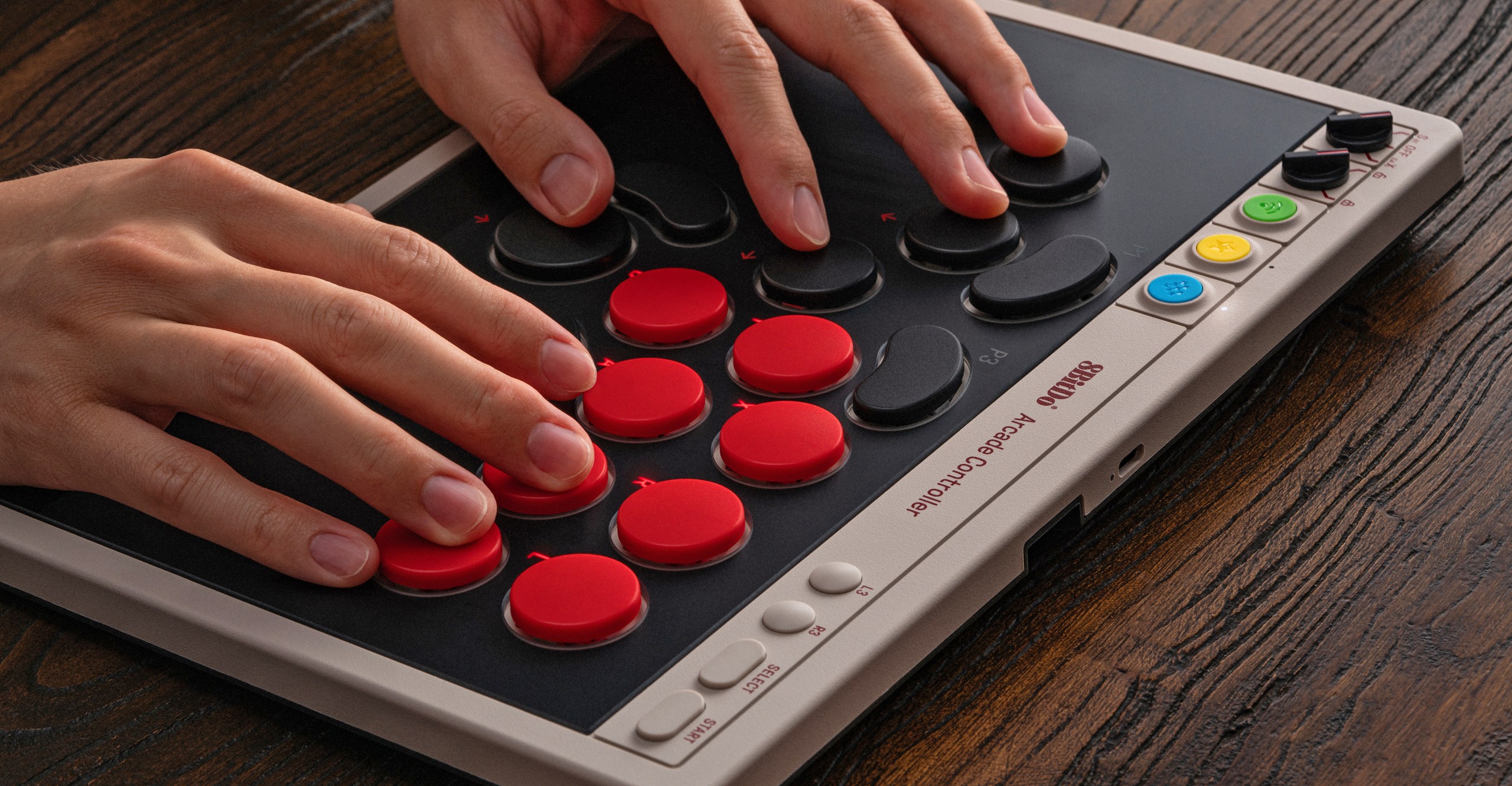 A person with two hands on 8BitDo’s leverless Arcade Controller.