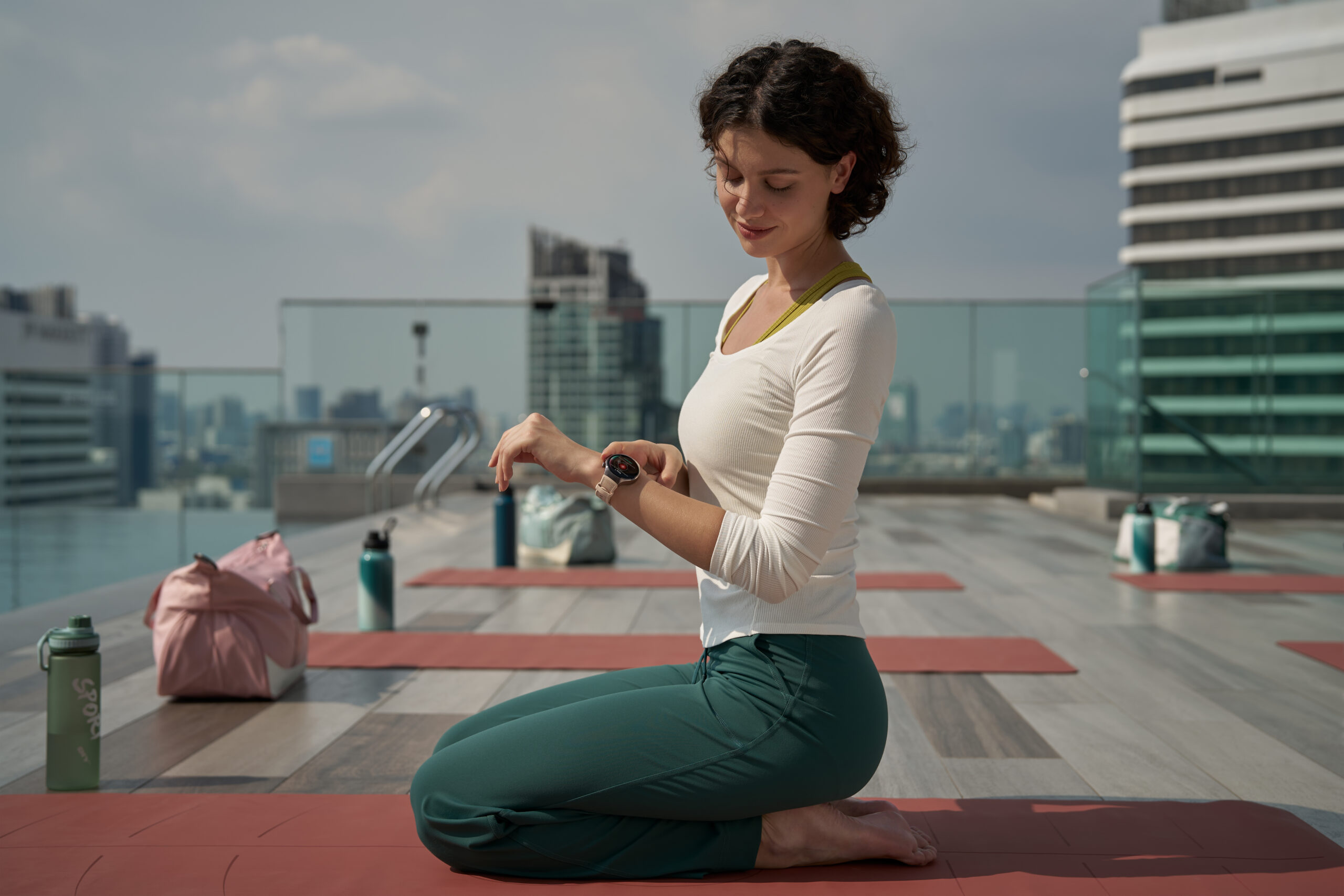 Woman doing yoga placing finger on the side of the Huawei Watch 5.