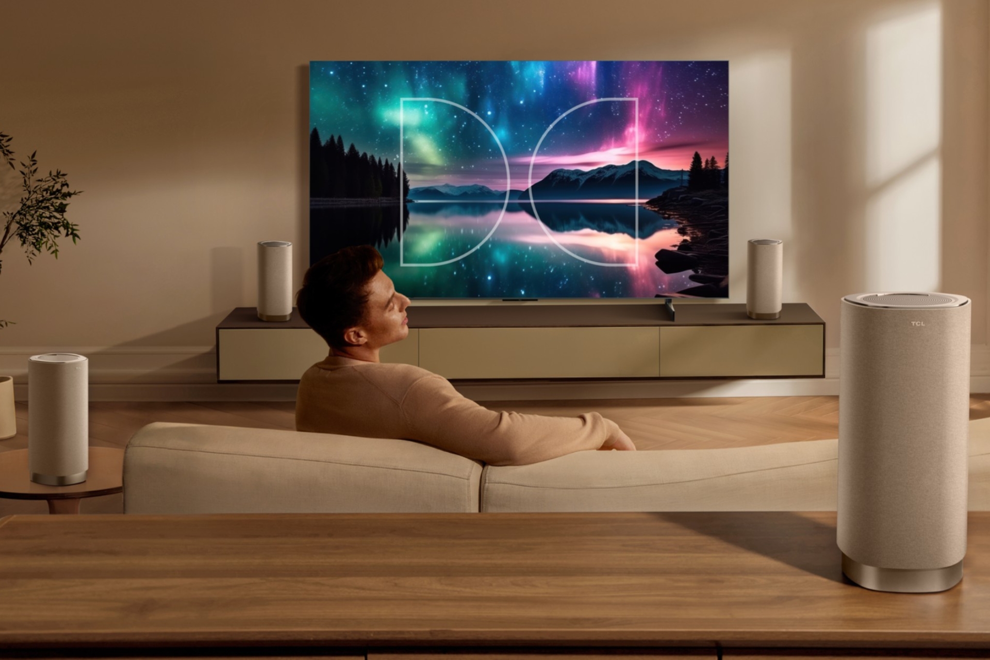 An image of someone watching a TCL TV surrounded by four Z100 speakers.