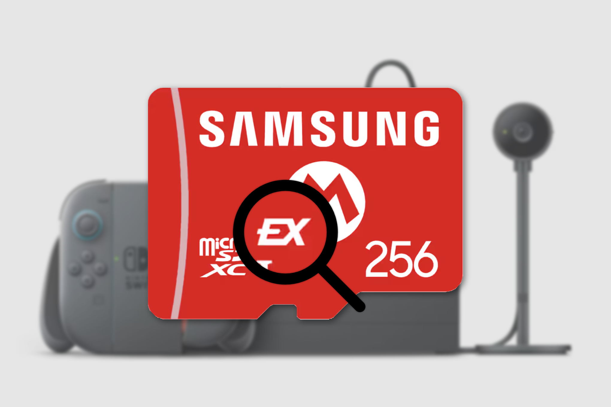 An image of the Nintendo Switch 2 sitting in its dock, with its Joy-Con 2 controllers in the included cradle, next to the webcam. In the foreground is a Samsung microSD Express card with a magnifying glass graphic focusing on the “EX” insignia, which indicates that it’s an Express model that’s compatible with the Switch 2.