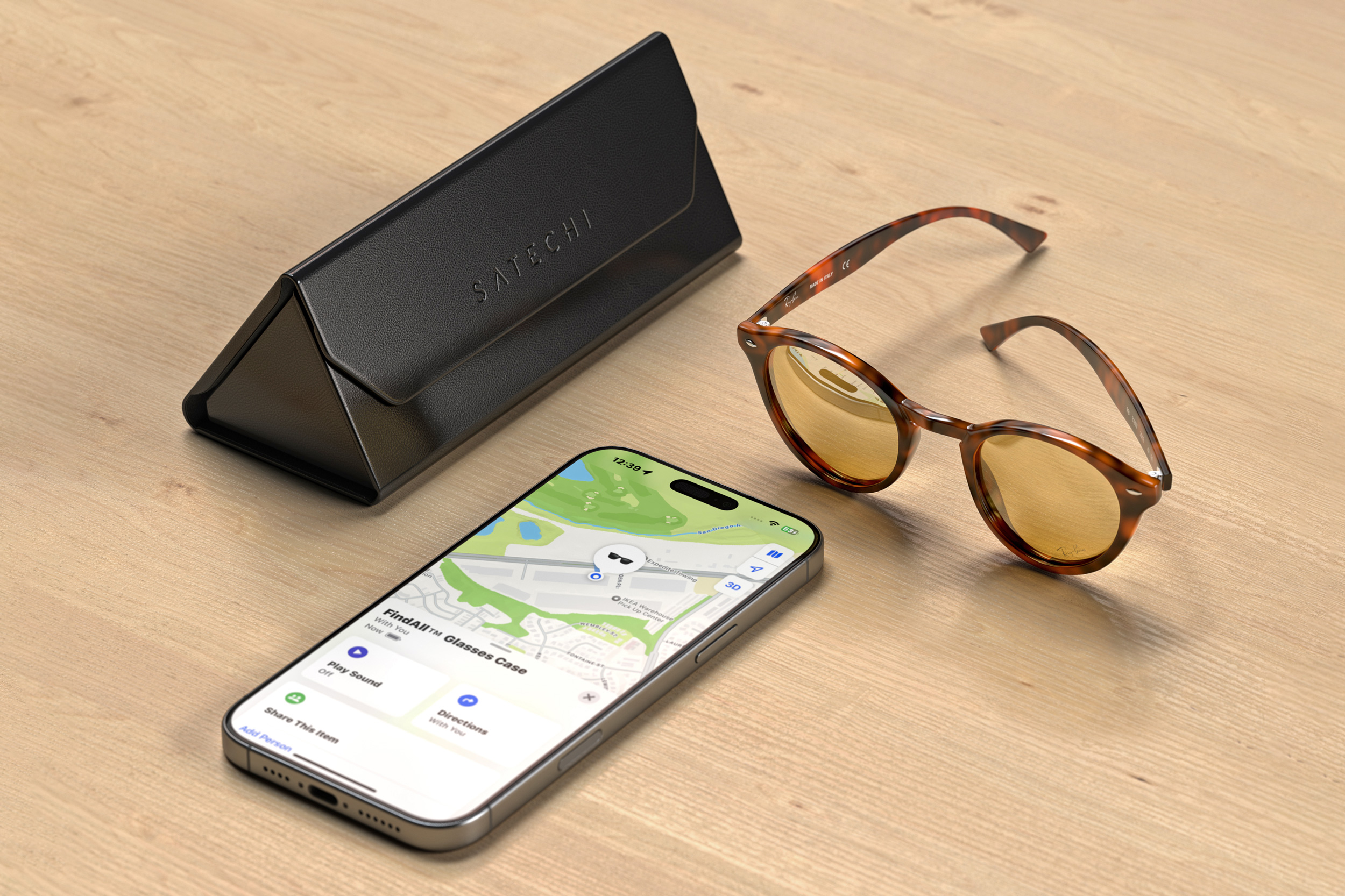 Satechi’s new trackable glasses case in black next to an iPhone and a pair of glasses.