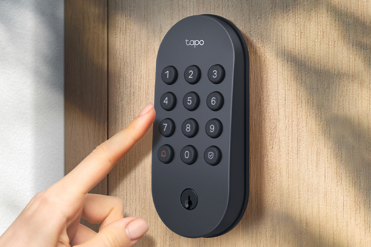 A person’s extended finger reaching to press a button on the Tapo DL100 smart door lock.
