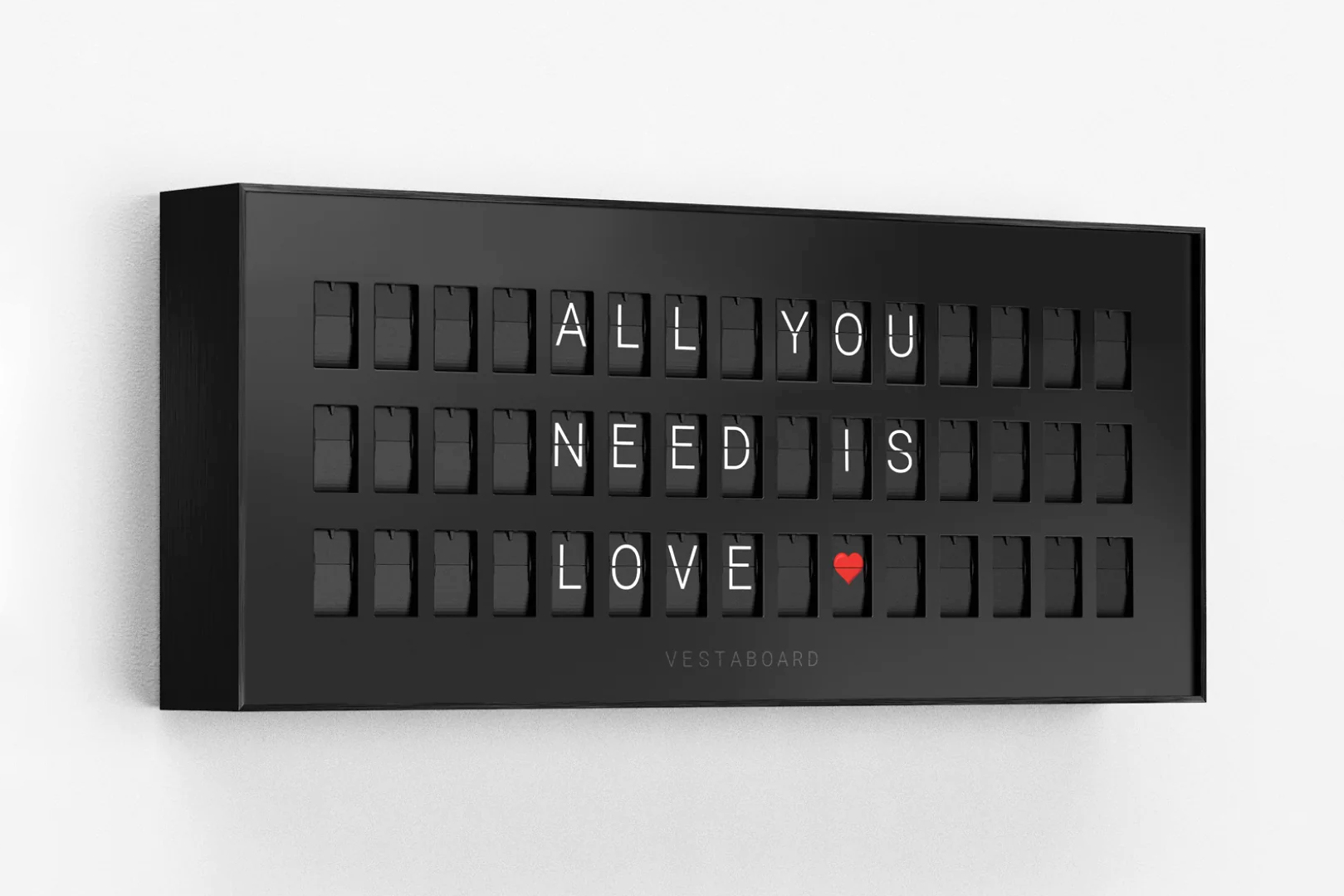 The Vestaboard Note attached to an off-white wall showing a message with a heart at the end.