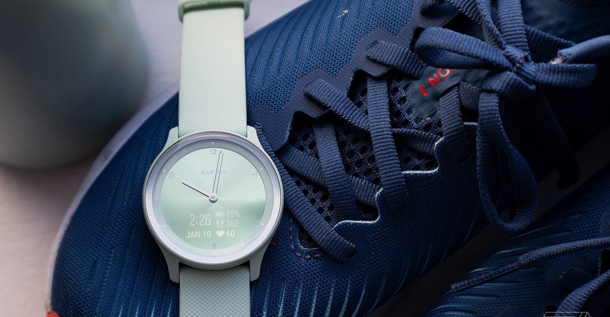 Garmin Vivomove Sport on top of a blue pair of sneakers
