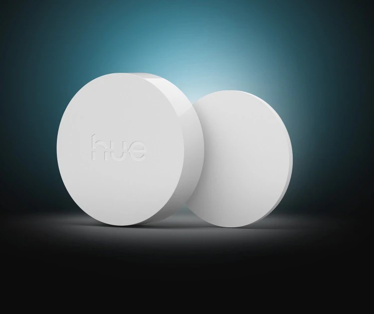 The white Hue Button V3 and its plate for wall mounting.
