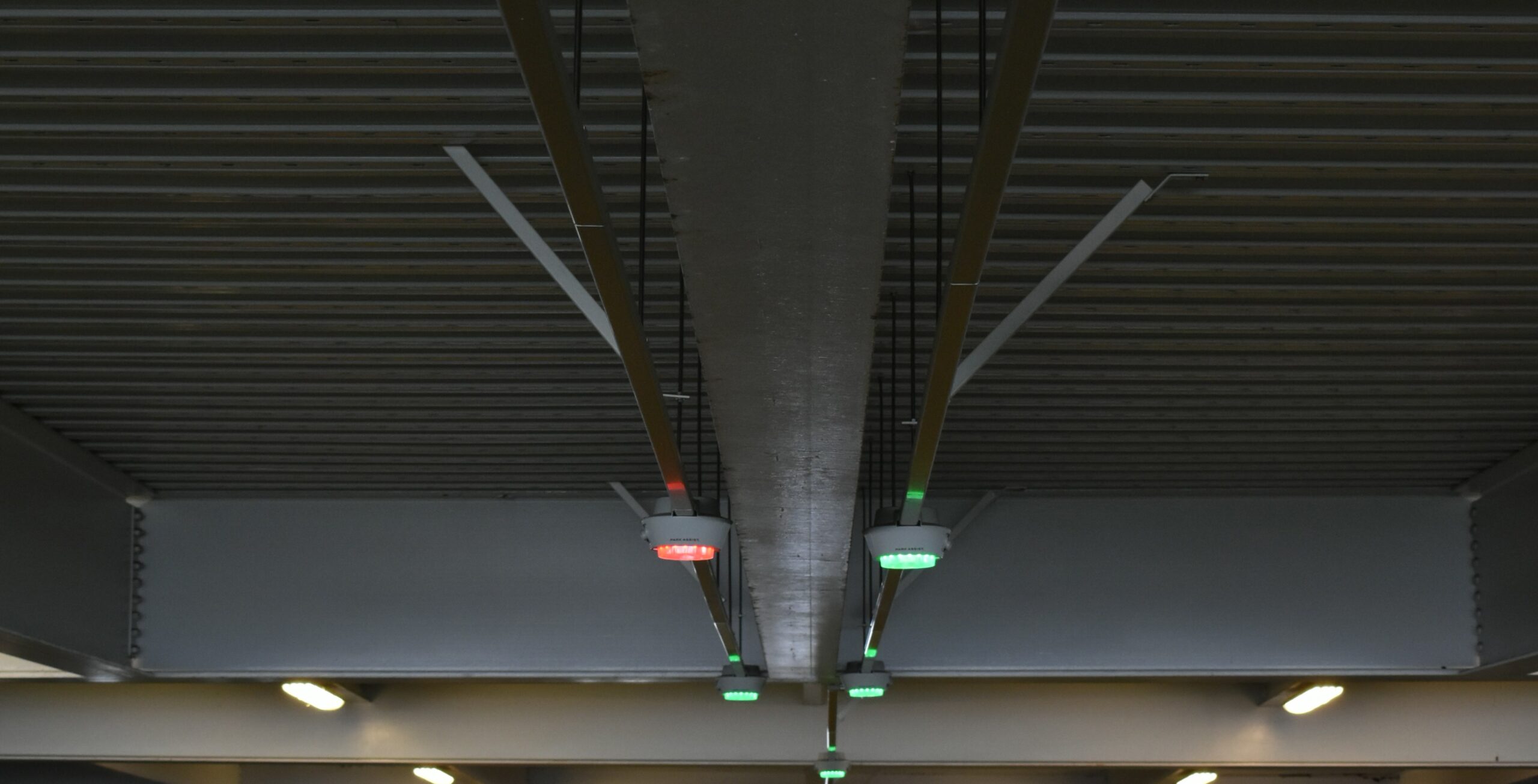 Airport parking garage. Red and green lights indicate occupied or vacant spaces ahead.