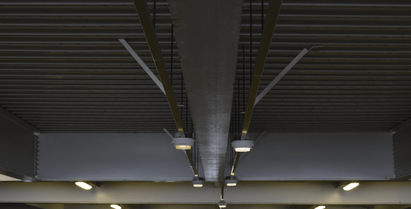 Airport parking garage. Red and green lights indicate occupied or vacant spaces ahead. Image has been processed to simulate red-green colorblindness, so it is difficult to differentiate between the lights.
