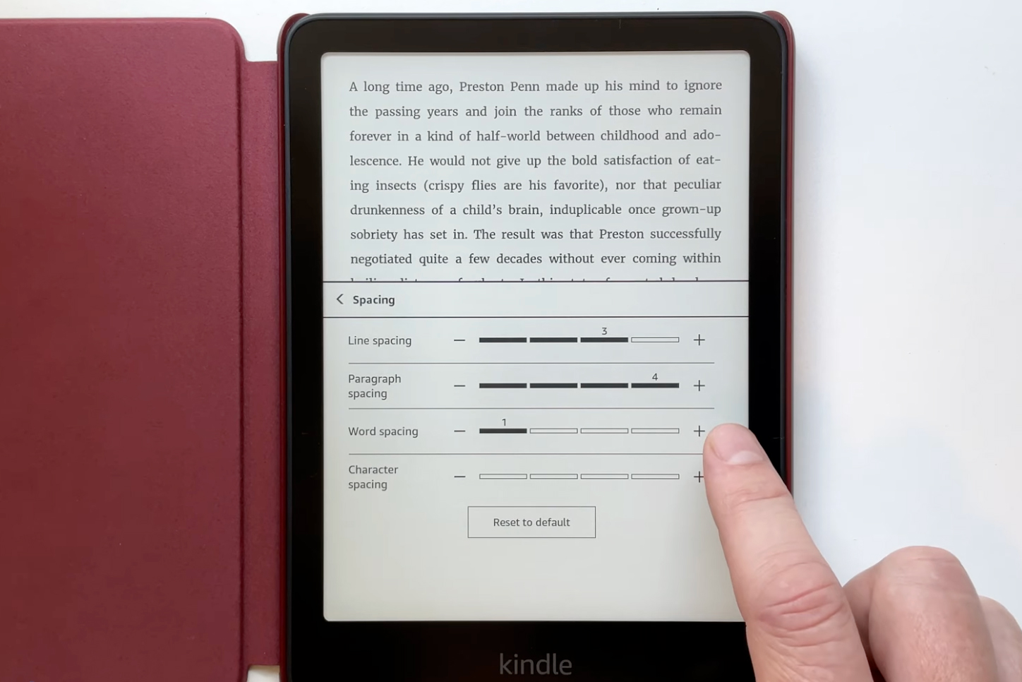 A finger tapping a Kindle screen making adjustments to word spacing.