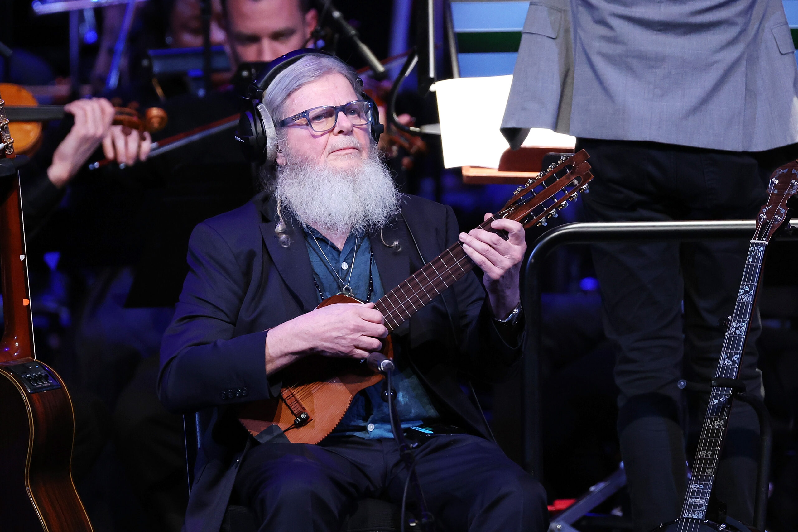 Gustavo Santaolalla holding a guitar.