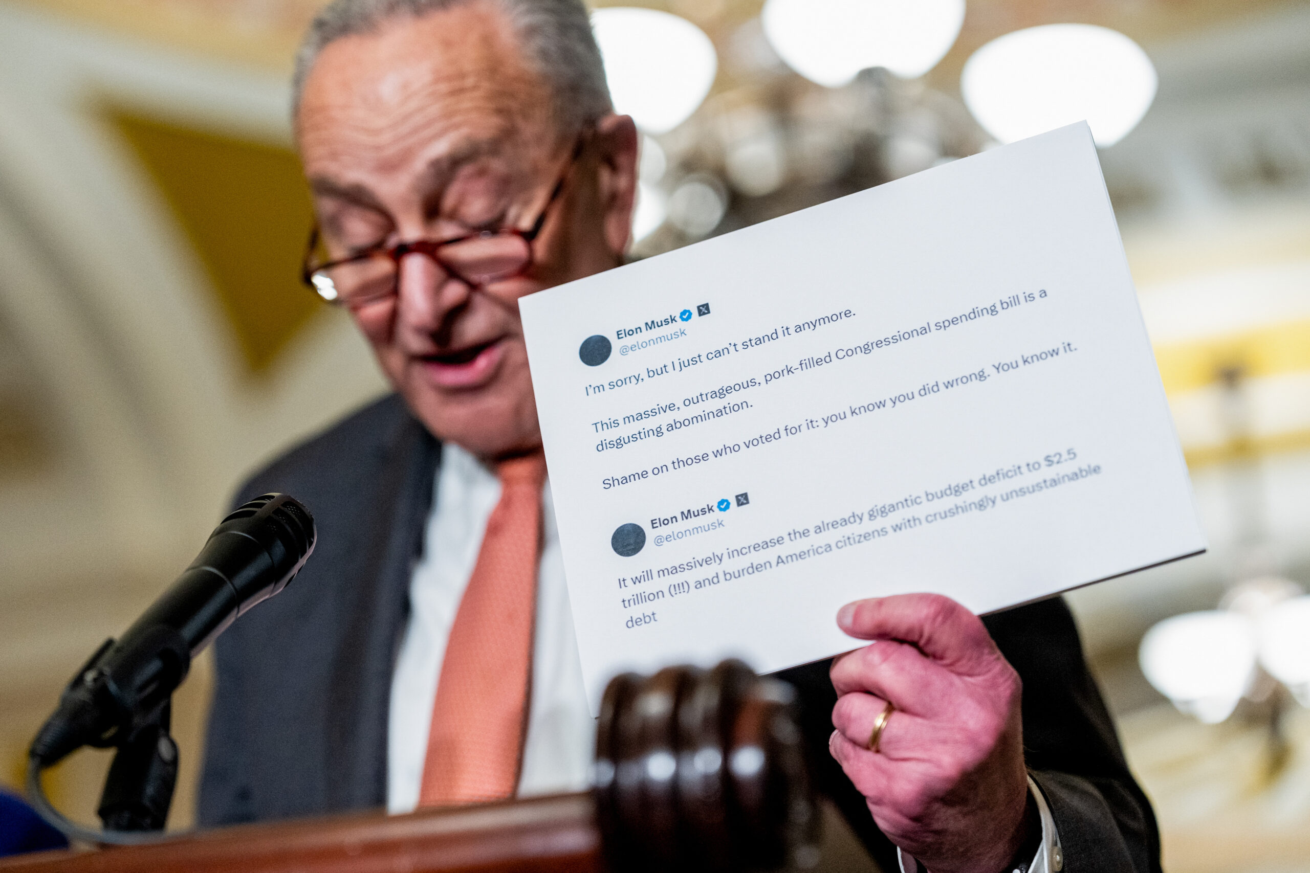 Senate Minority Leader Chuck Schumer, a Democrat from New York, holds an X post from Elon Musk, chief executive officer of Tesla Inc., that criticizes the Congressional spending bill.