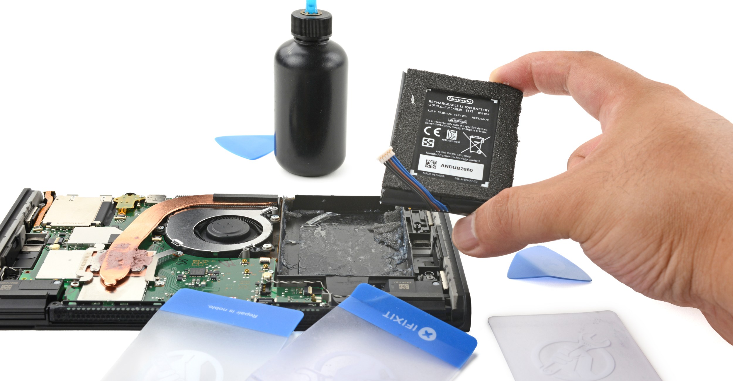 A half-disassembled Nintendo Switch 2 console with a hand holding its battery.