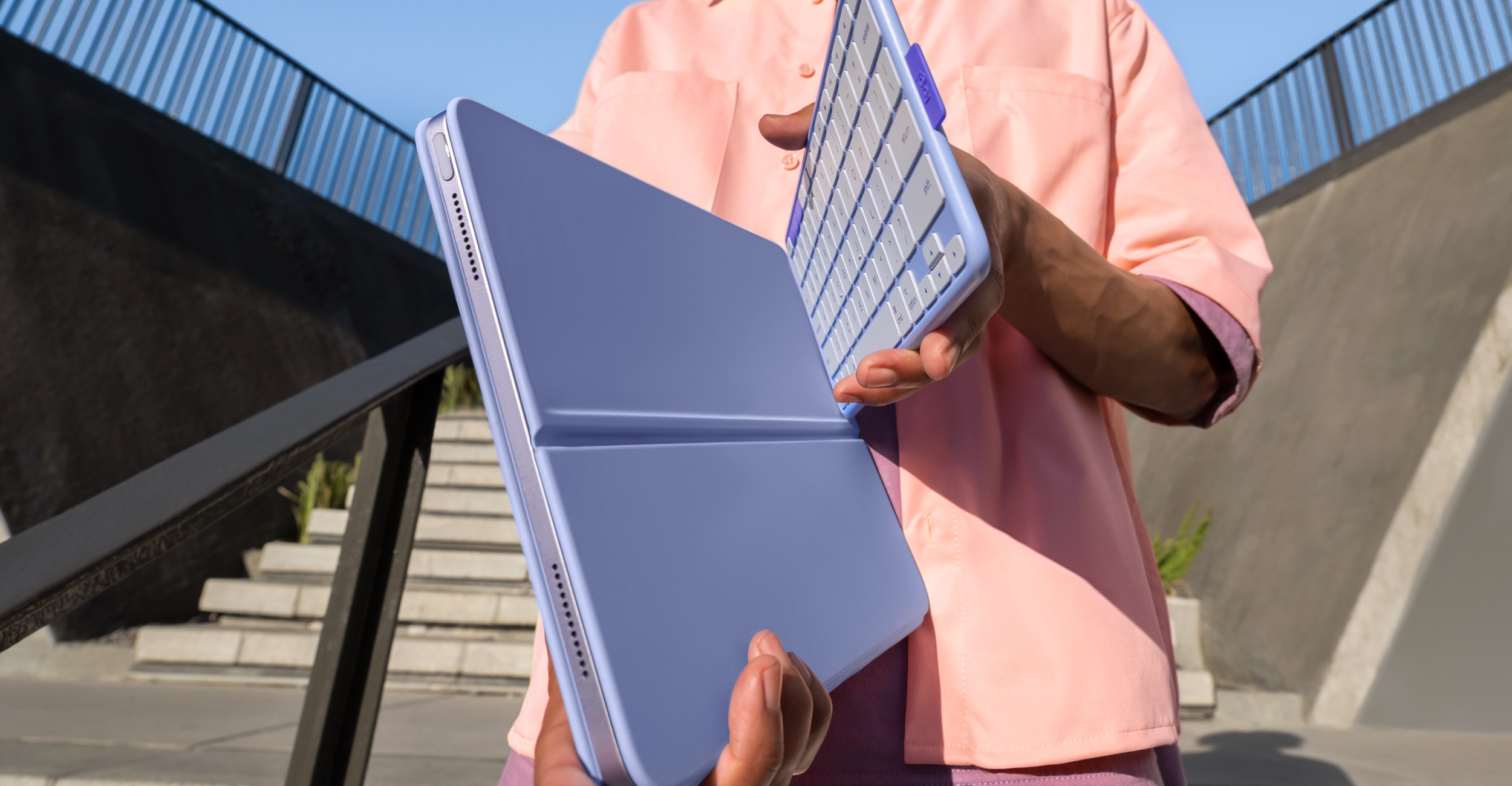 A person holding the Flip Folio case with its keyboard half attached.