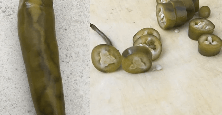 A chili pepper that appears nearly uniformly green.