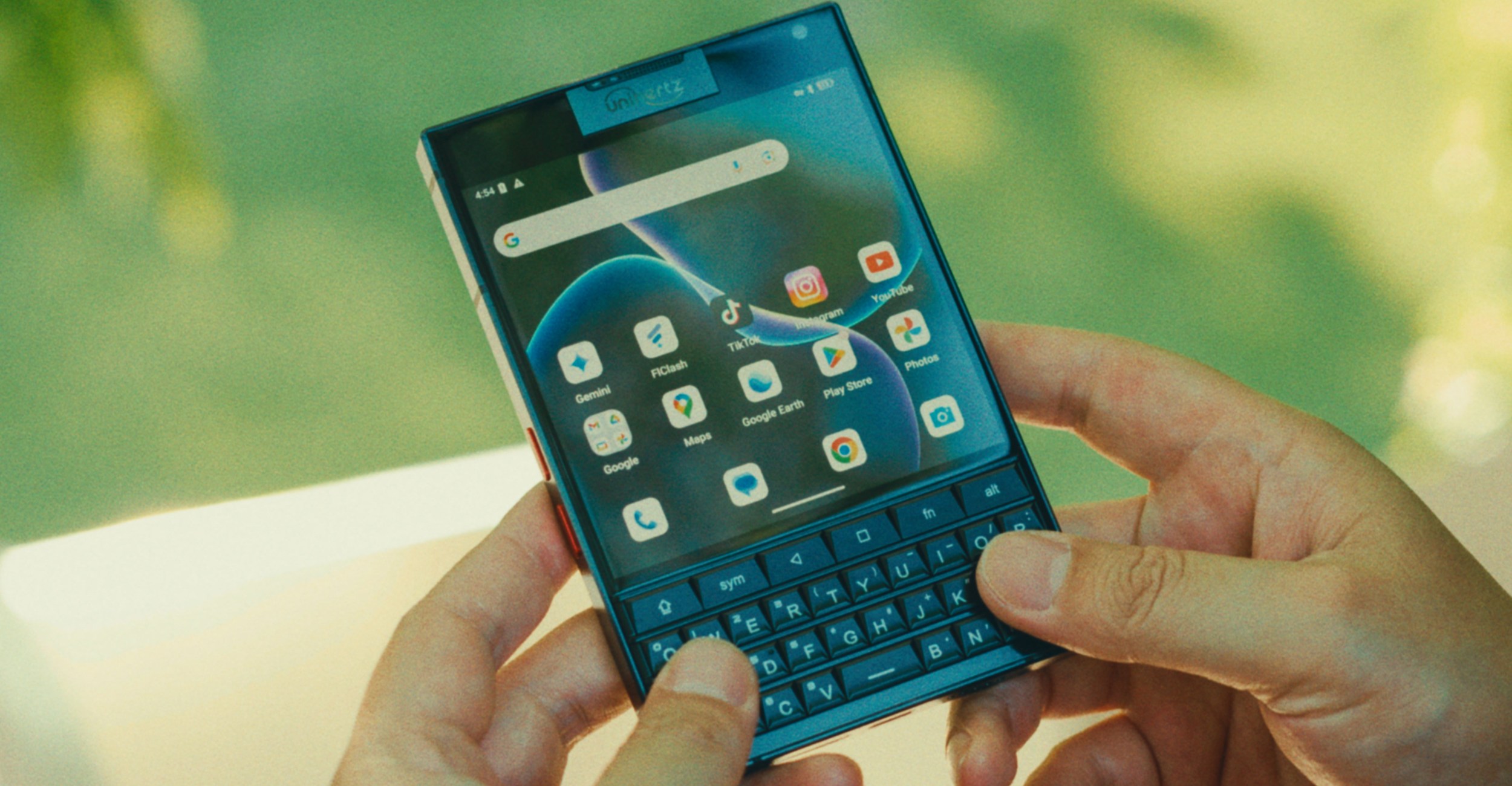 A person holds the Unihertz Titan 2 smartphone in two hands.