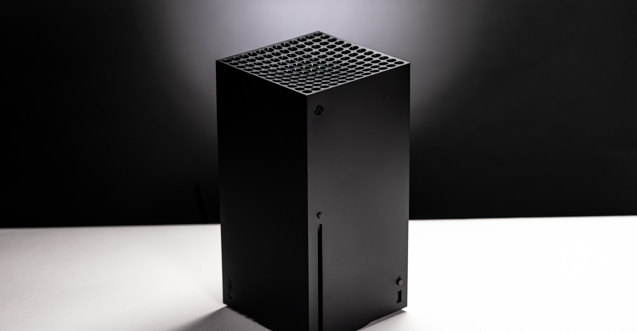 An Xbox Series X console is placed on a white surface with a black background behind it.