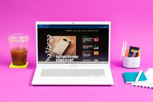 The Asus Chromebook Plus CX34 displaying The Verge homepage between an iced coffee and a cup of colored pencils.