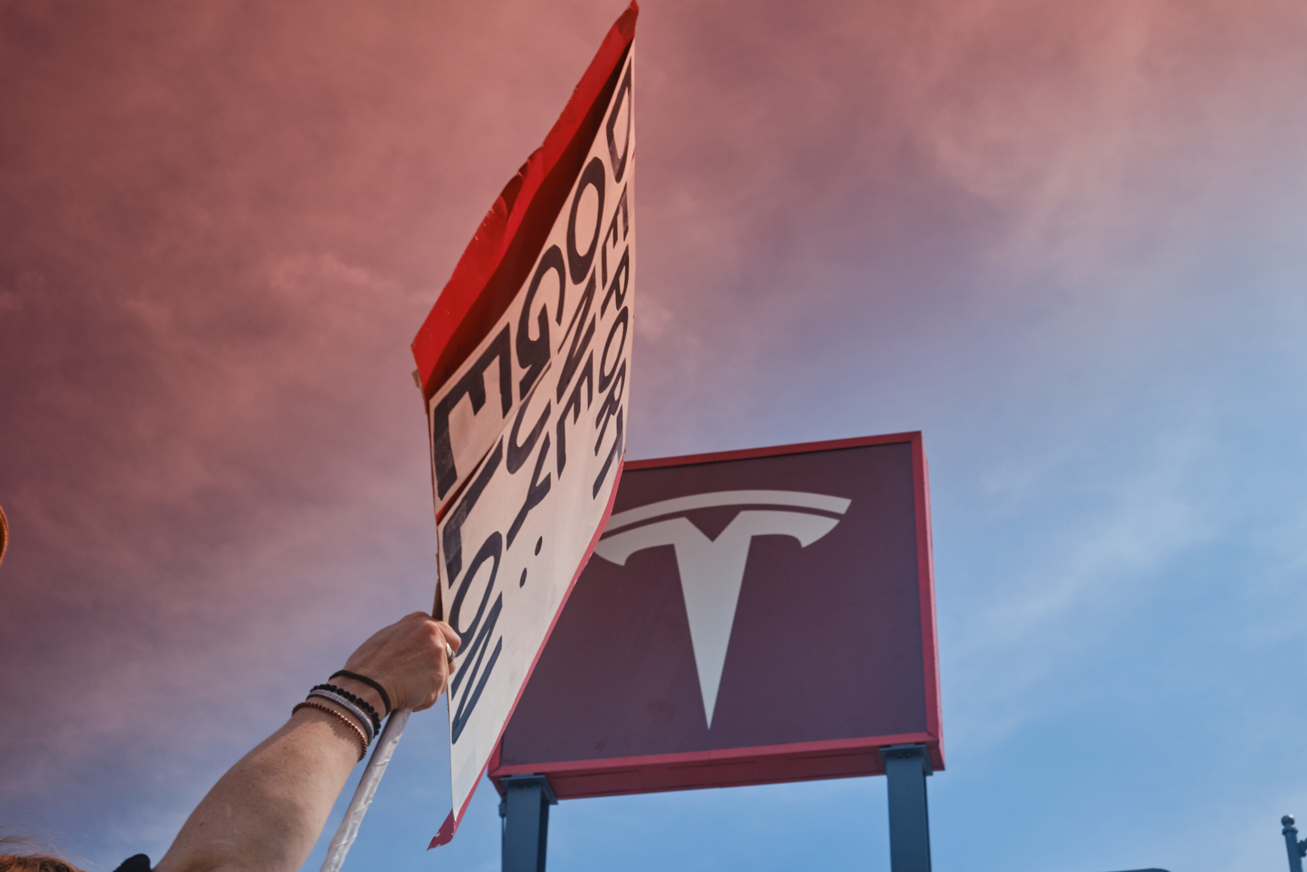 Tesla sign and protest signage outside the North Hollywood Tesla showroom during the #TeslaTakedown protest.