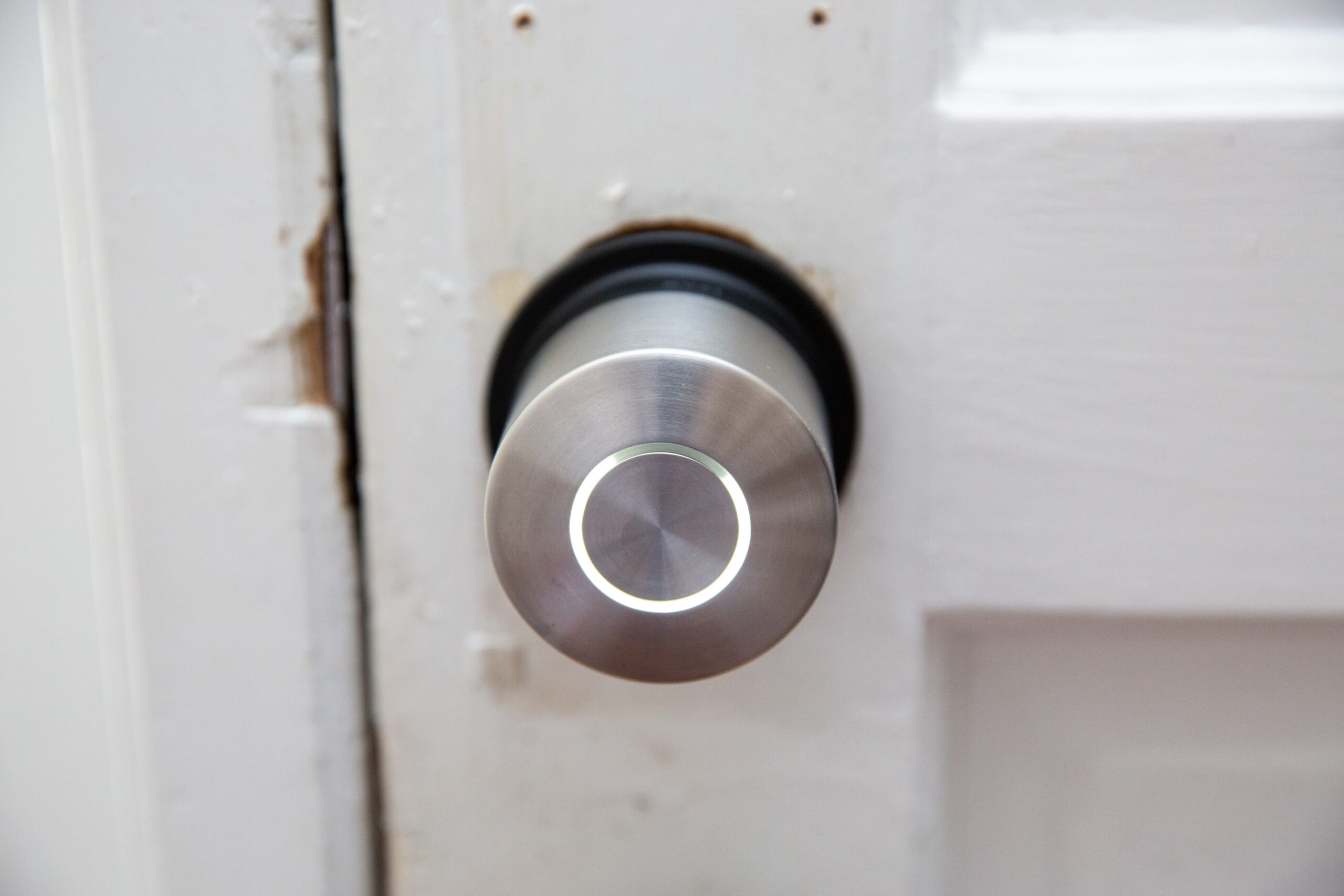 A small silver lock on a white door.
