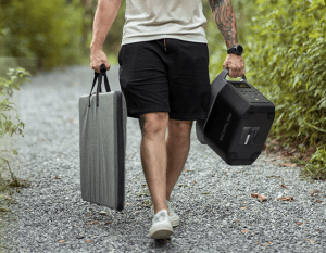 A person carrying the EcoFlow Delta 2 and a solar panel in a carrying case.