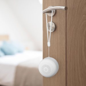 The Yogasleep Travel Mini Portable Sound Machine hanging from a doorknob.