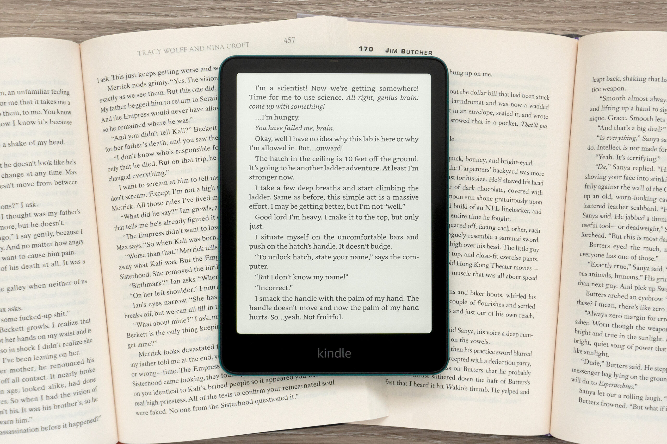 The Amazon Kindle Paperwhite sitting on top of a pair of open books.