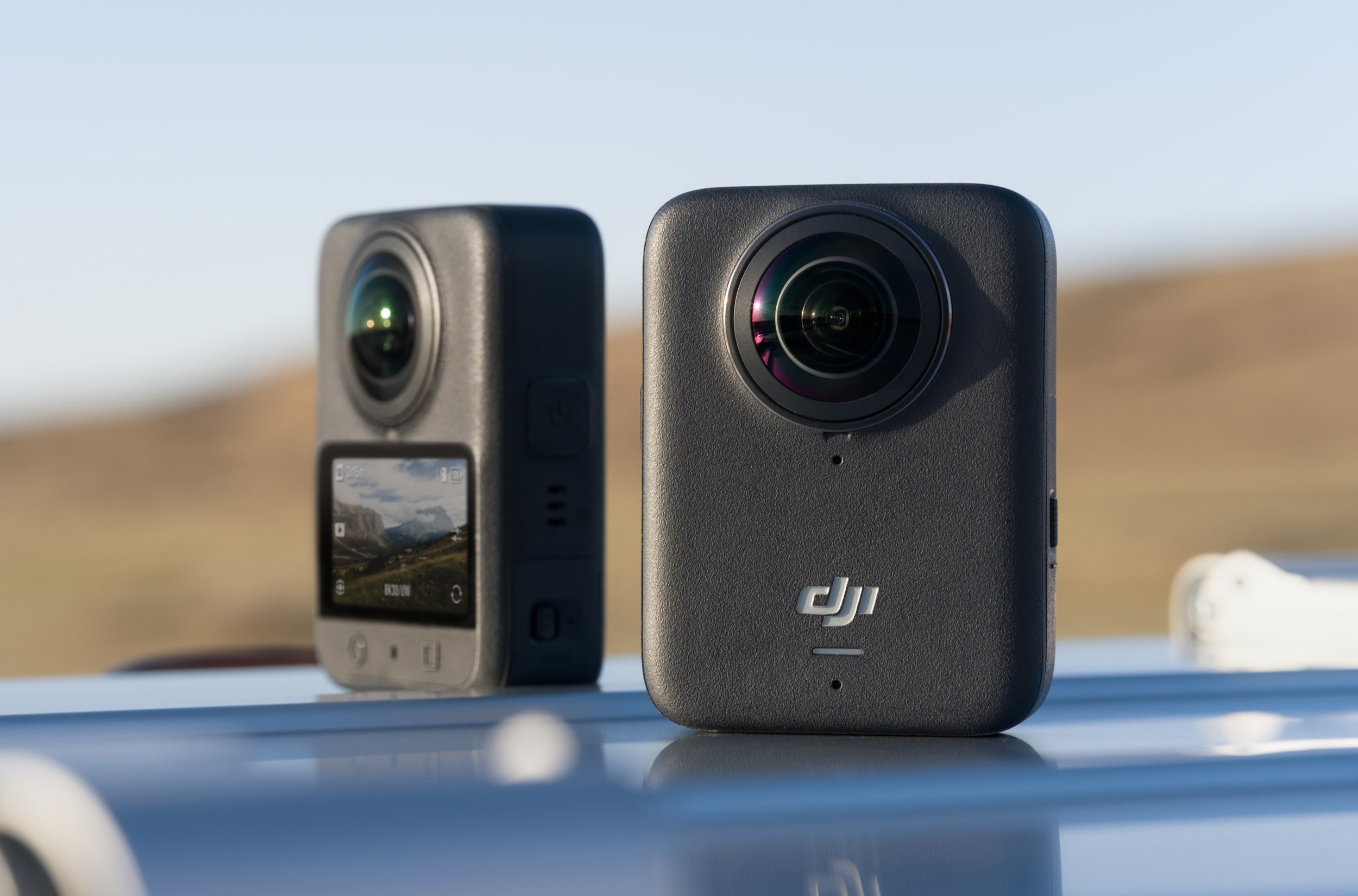 Two of DJI’s Osmo 360 action cameras showing the front and back of the device. Two of DJI’s Osmo 360 action cameras showing the front and back of the device.