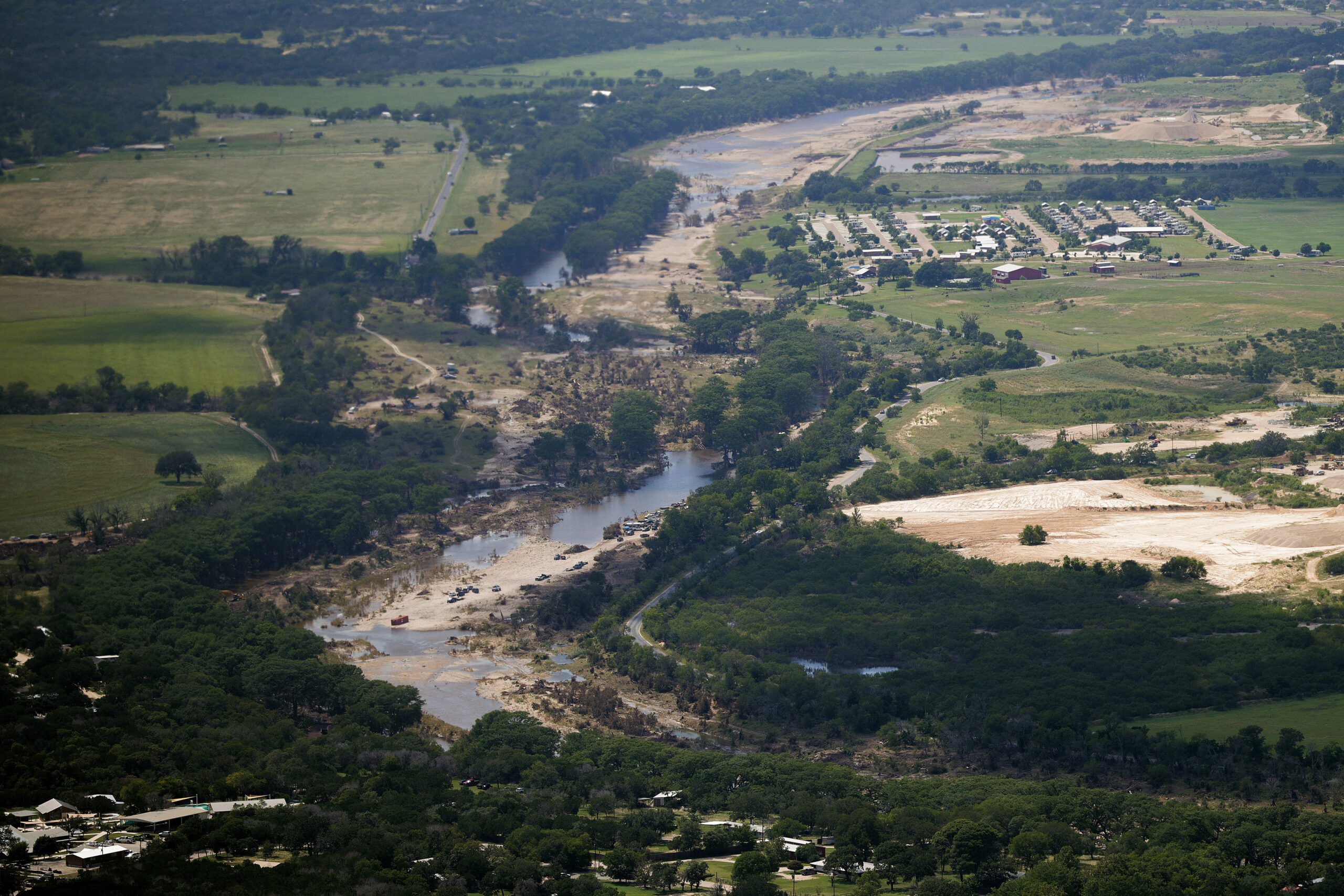 An aerial view of a river with muddy banks after a flood.