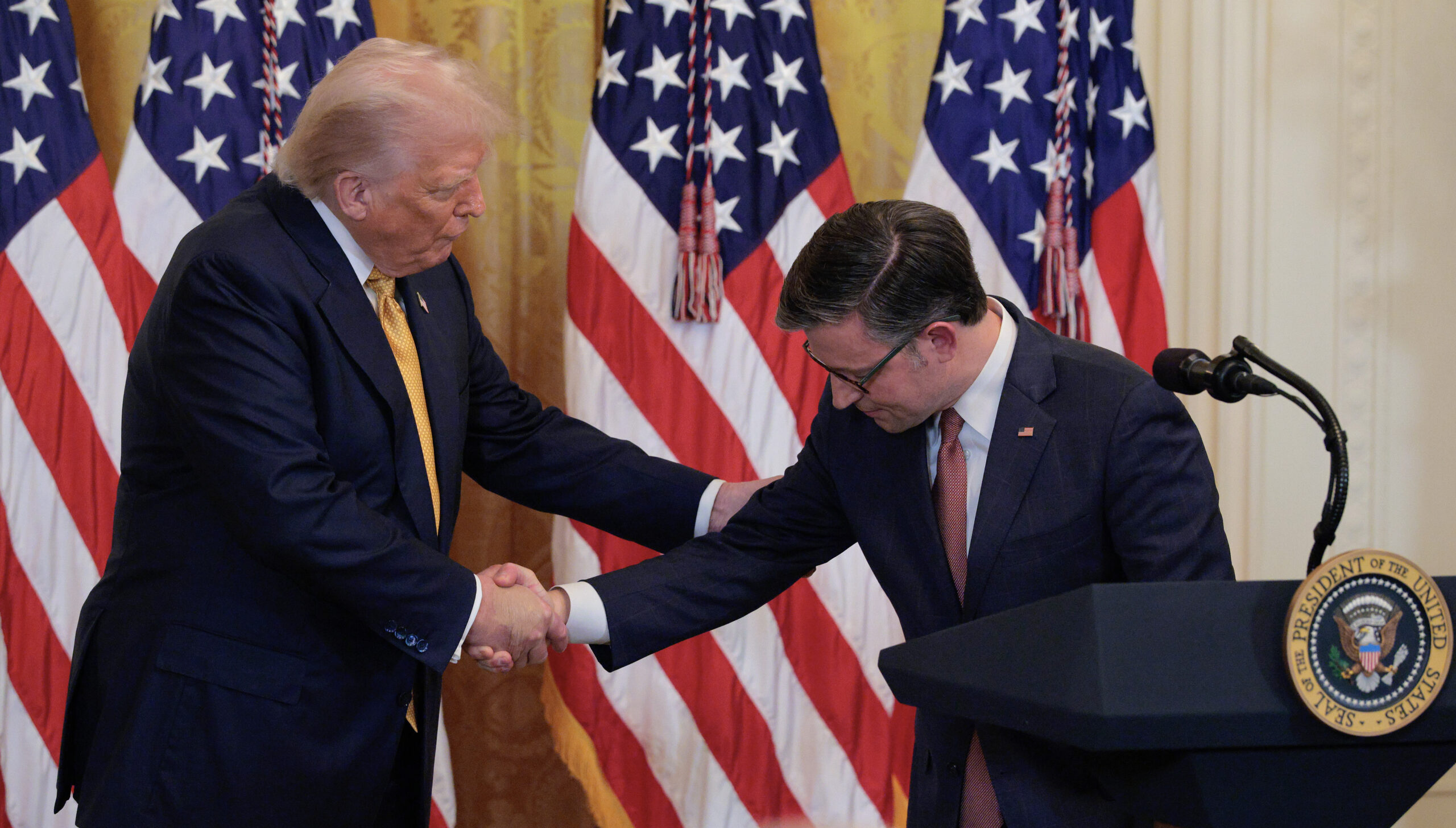 House Speaker Mike Johnson shakes hands with President Donald Trump.