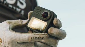 A close up shot of someone holding the GoPro Max action camera.