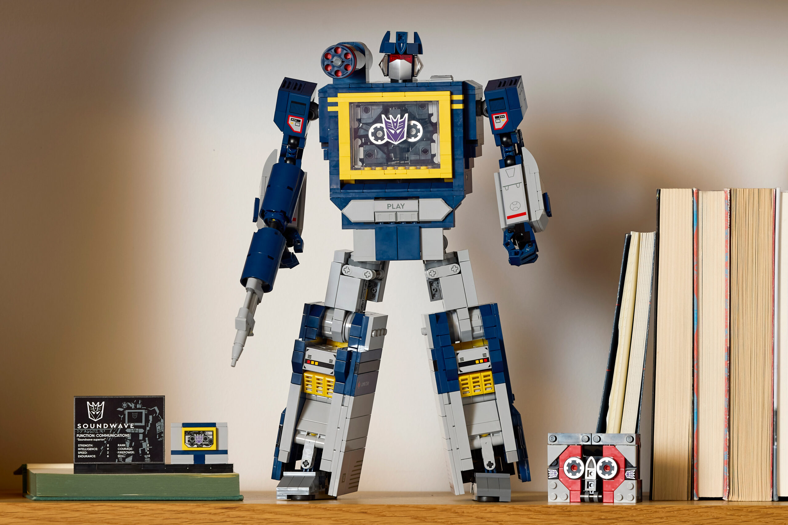The Lego Icons Transformers Soundwave set posed on a bookshelf.