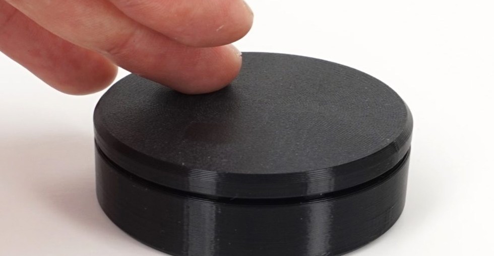 A finger touches the top of the Ploopy Knob.
