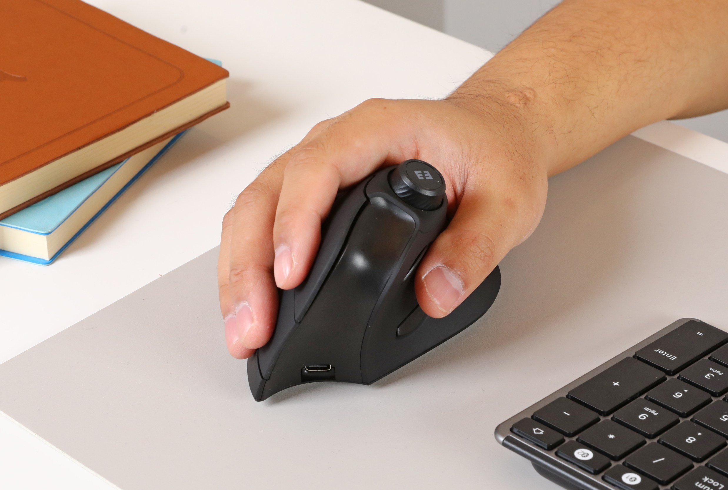 A person holding the black version of Seenda’s vertical ergonomic mouse.