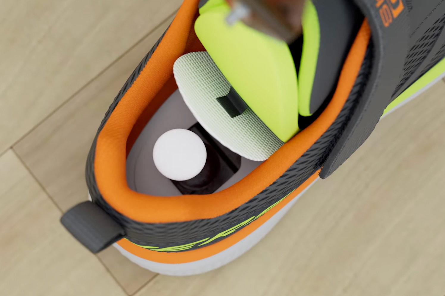 An Apple AirTag being inserted into one of the new Find My Skechers shoes.