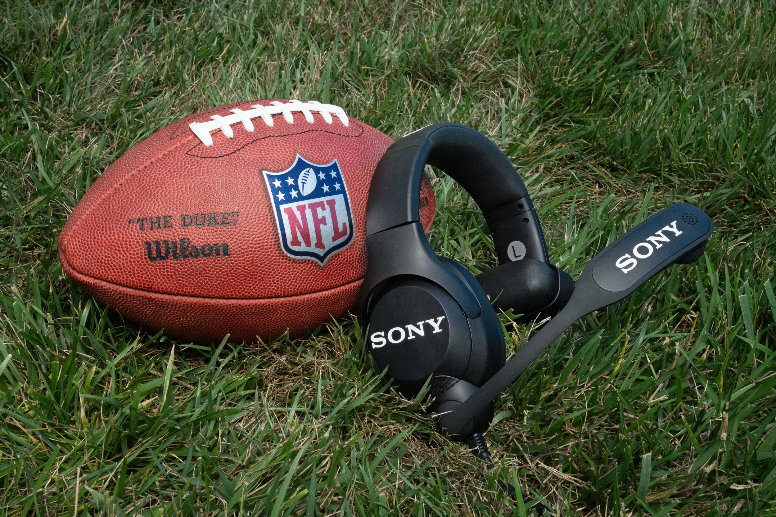 Sony’s headset for NFL coaches sitting on grass next to a football.