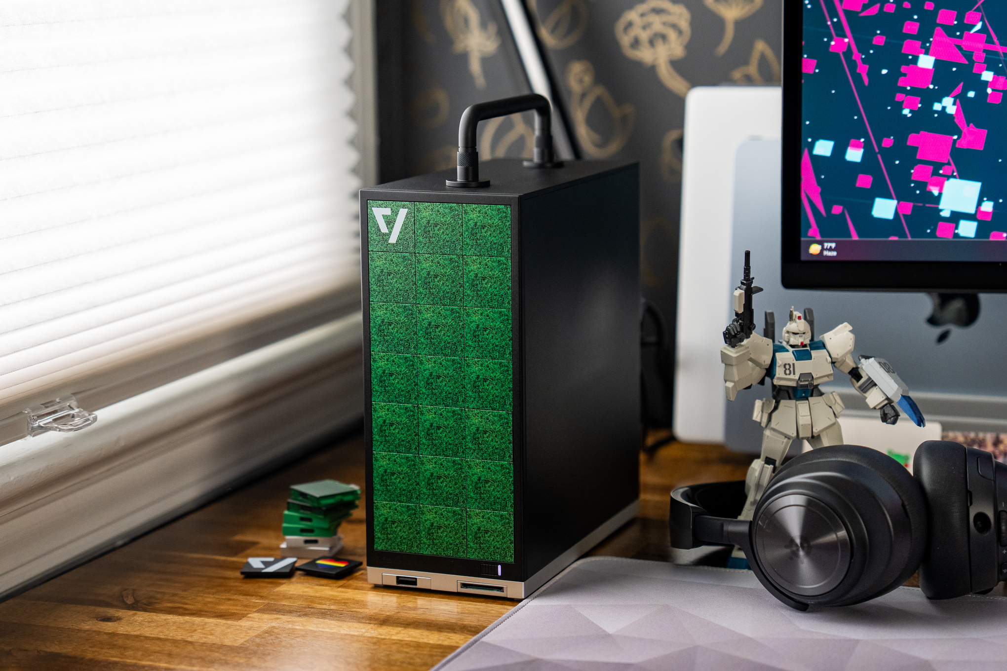 A Framework Desktop PC on a desk with various tech and figurines.