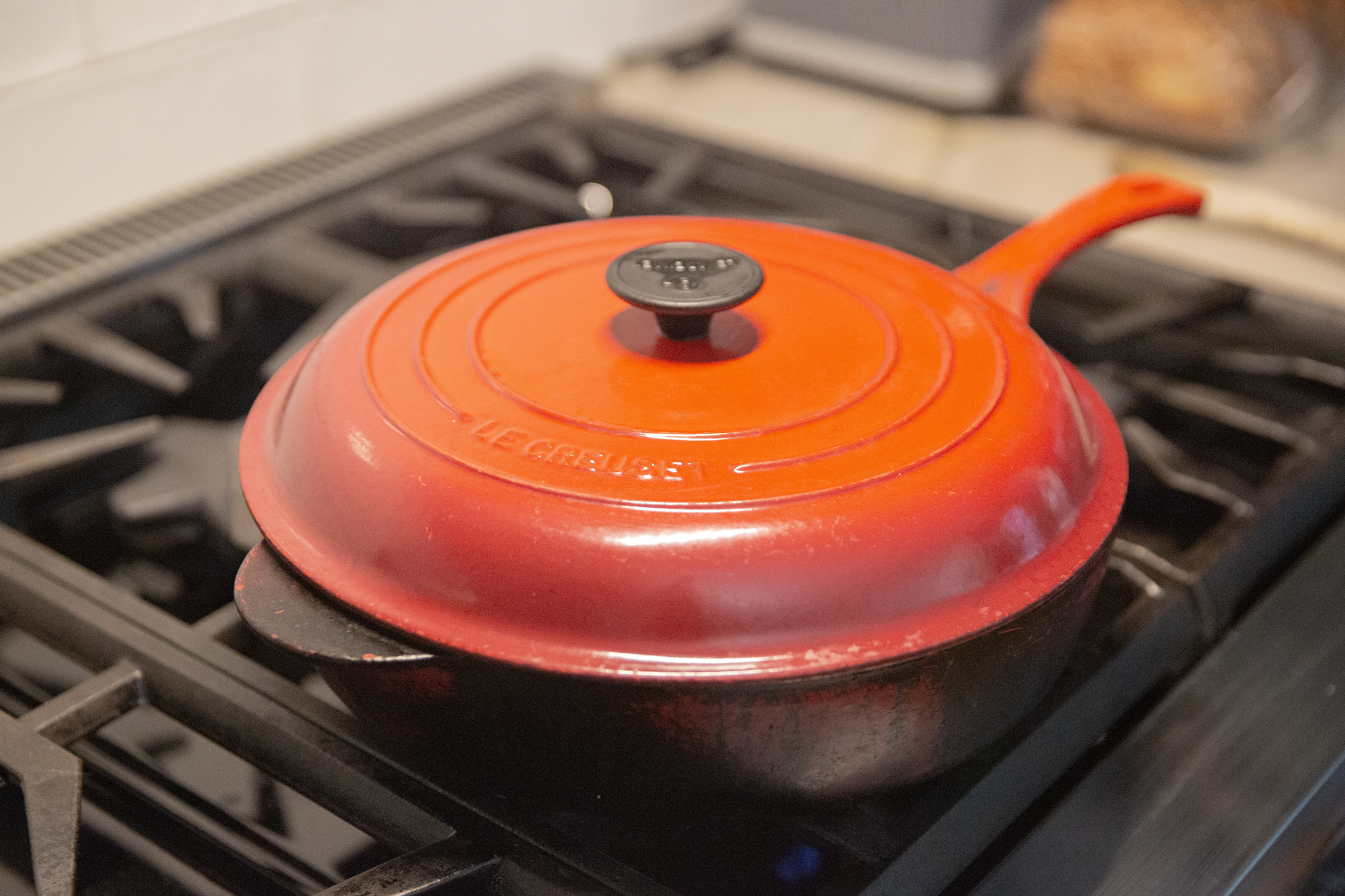 Red covered pan on stove.