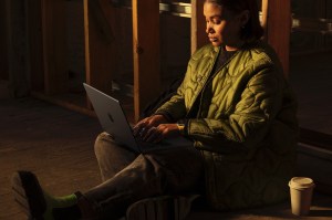 Someone sitting on ground using MacBook Pro