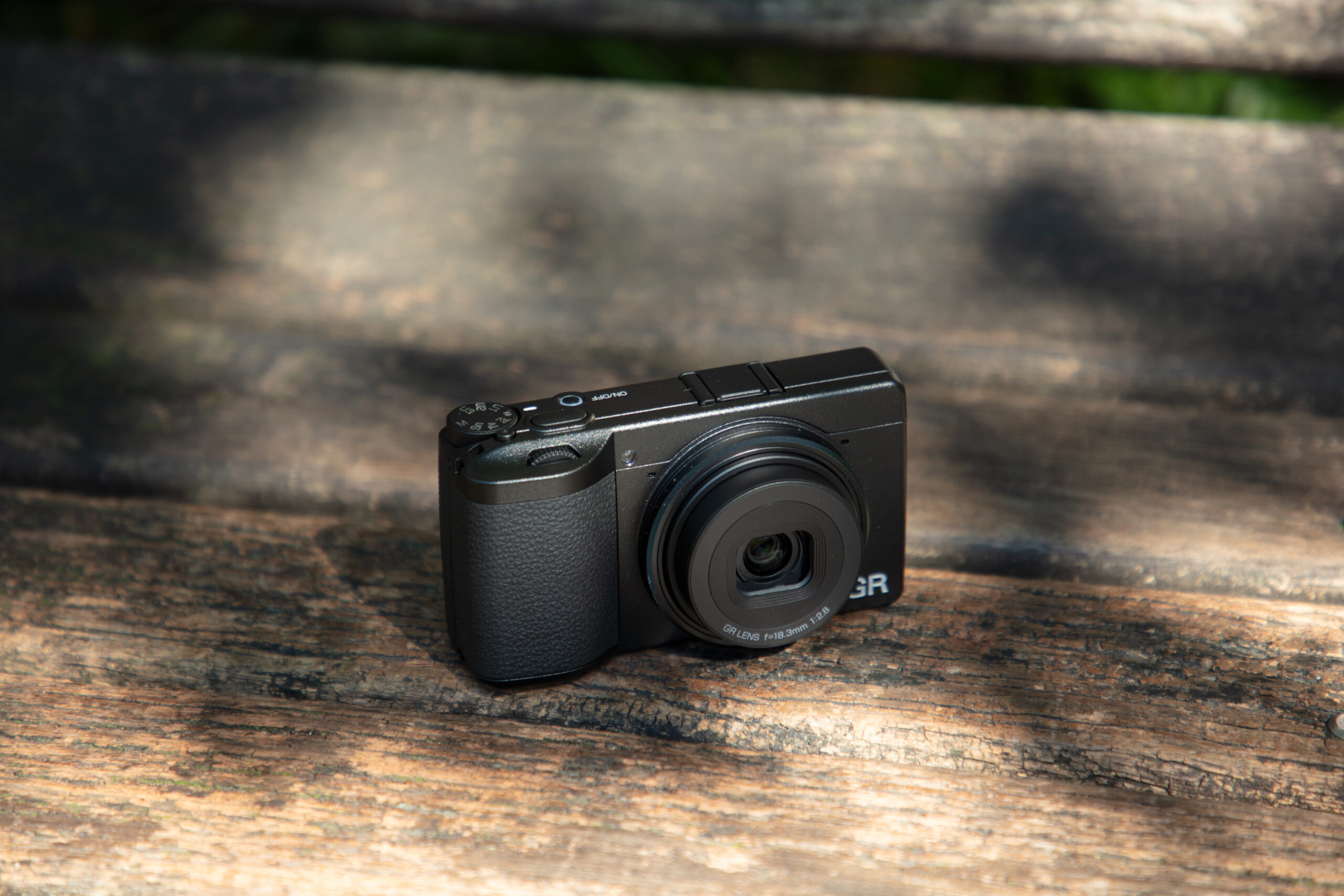 The Ricoh GR camera on a wood surface.