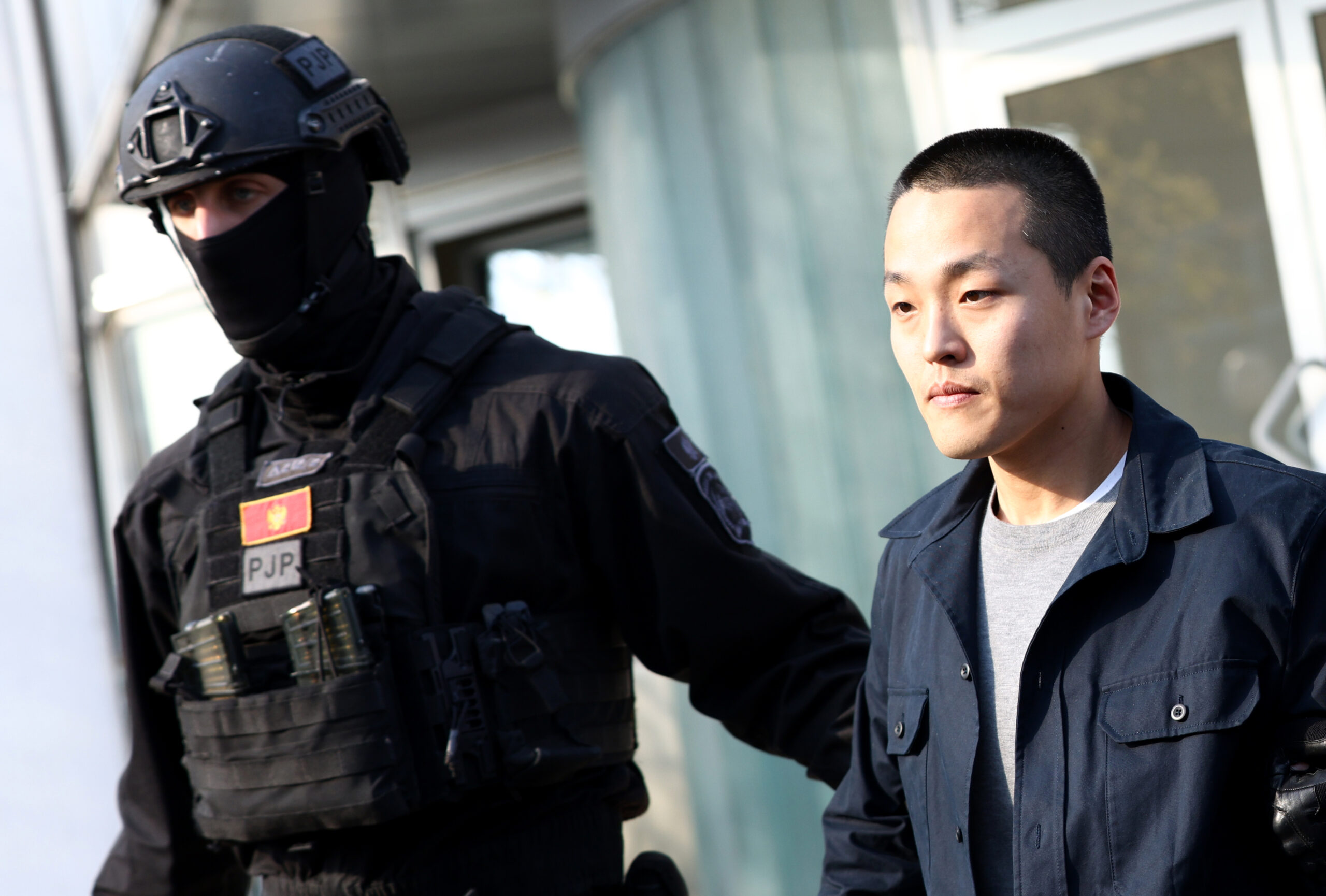 A photo showing Do Kwon being escorted by police officers in Montenegro