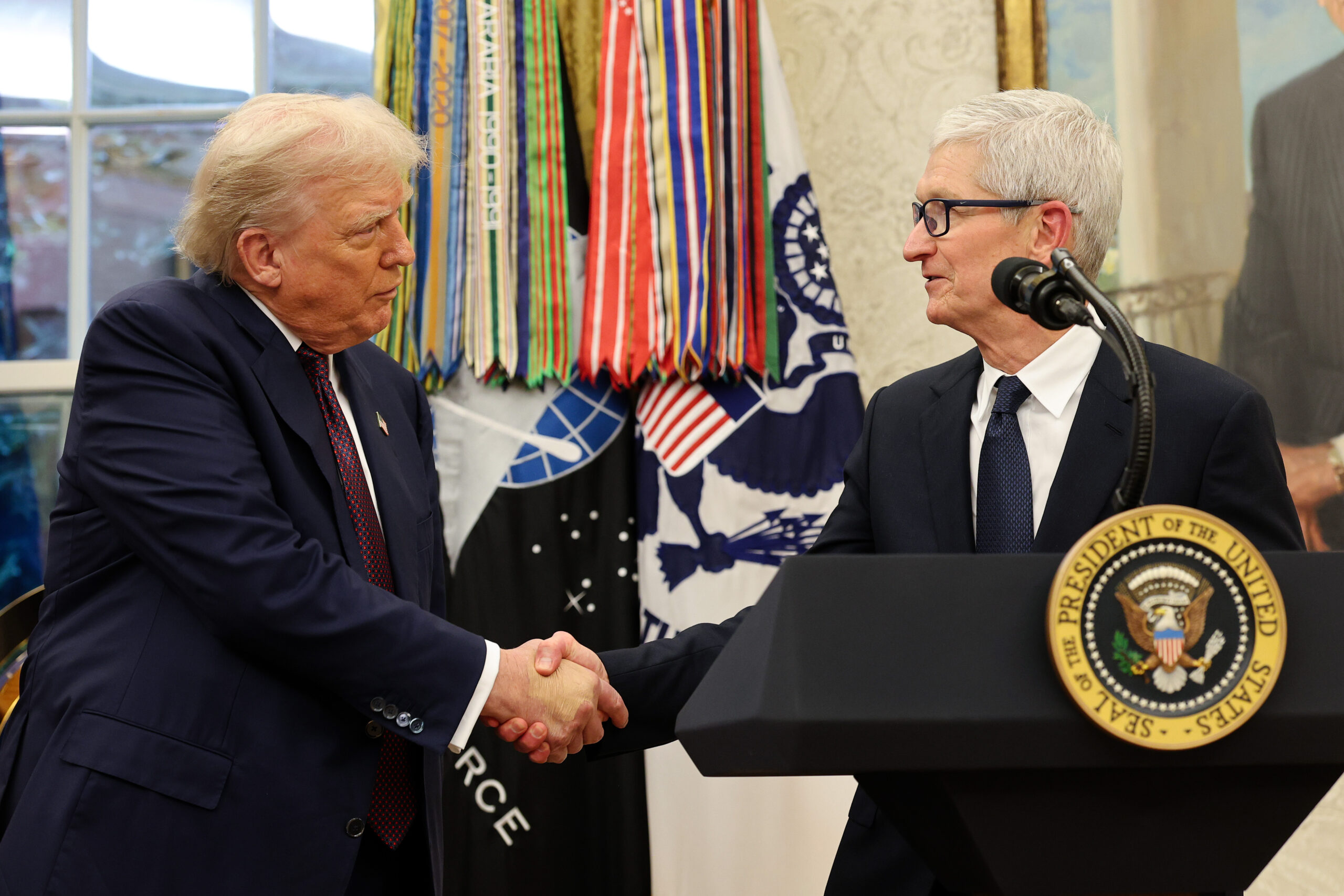 A photo showing Tim Cook and Trump shaking hands
