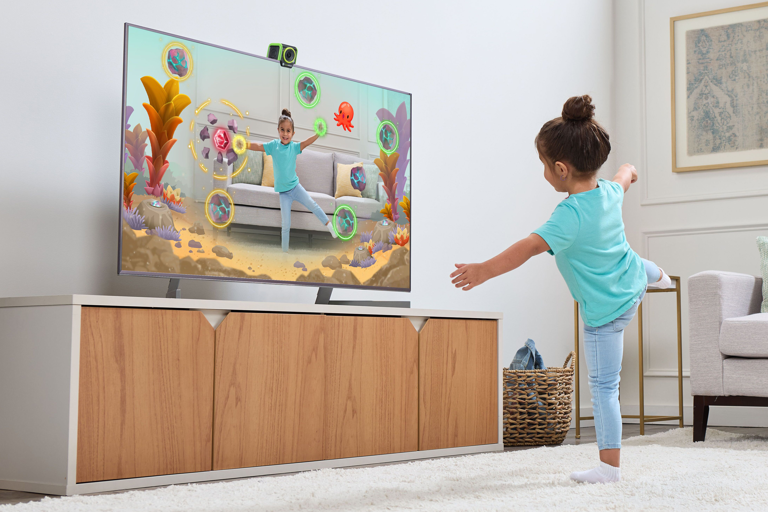 A child balances on one foot in front of a TV while playing a game on the LeapFrog LeapMove.