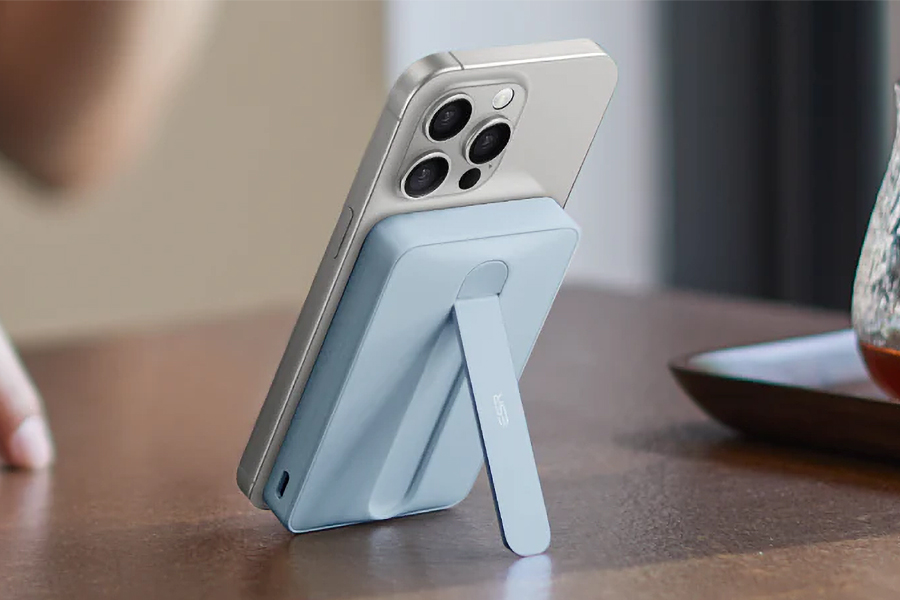 An ESR wireless power bank attached to an iPhone propped up on a desk.