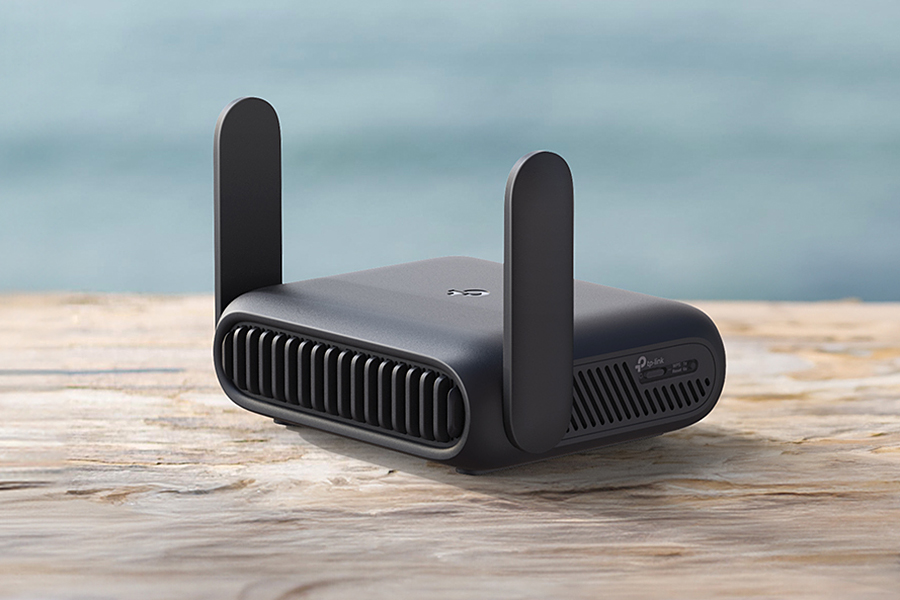 A close-up of TP-Link’s new Wi-Fi 7 travel router on a wooden table outdoors.
