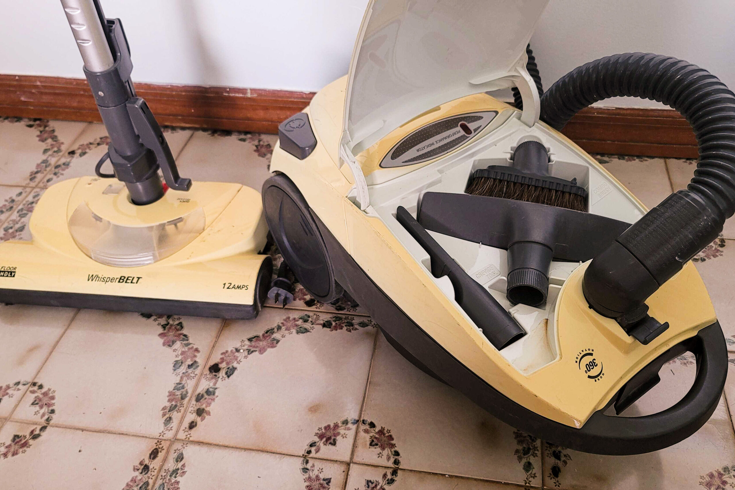 Closeup of old-fashioned vacuum with open cannister showing various attachments. Closeup of old-fashioned vacuum with open cannister showing various attachments.
