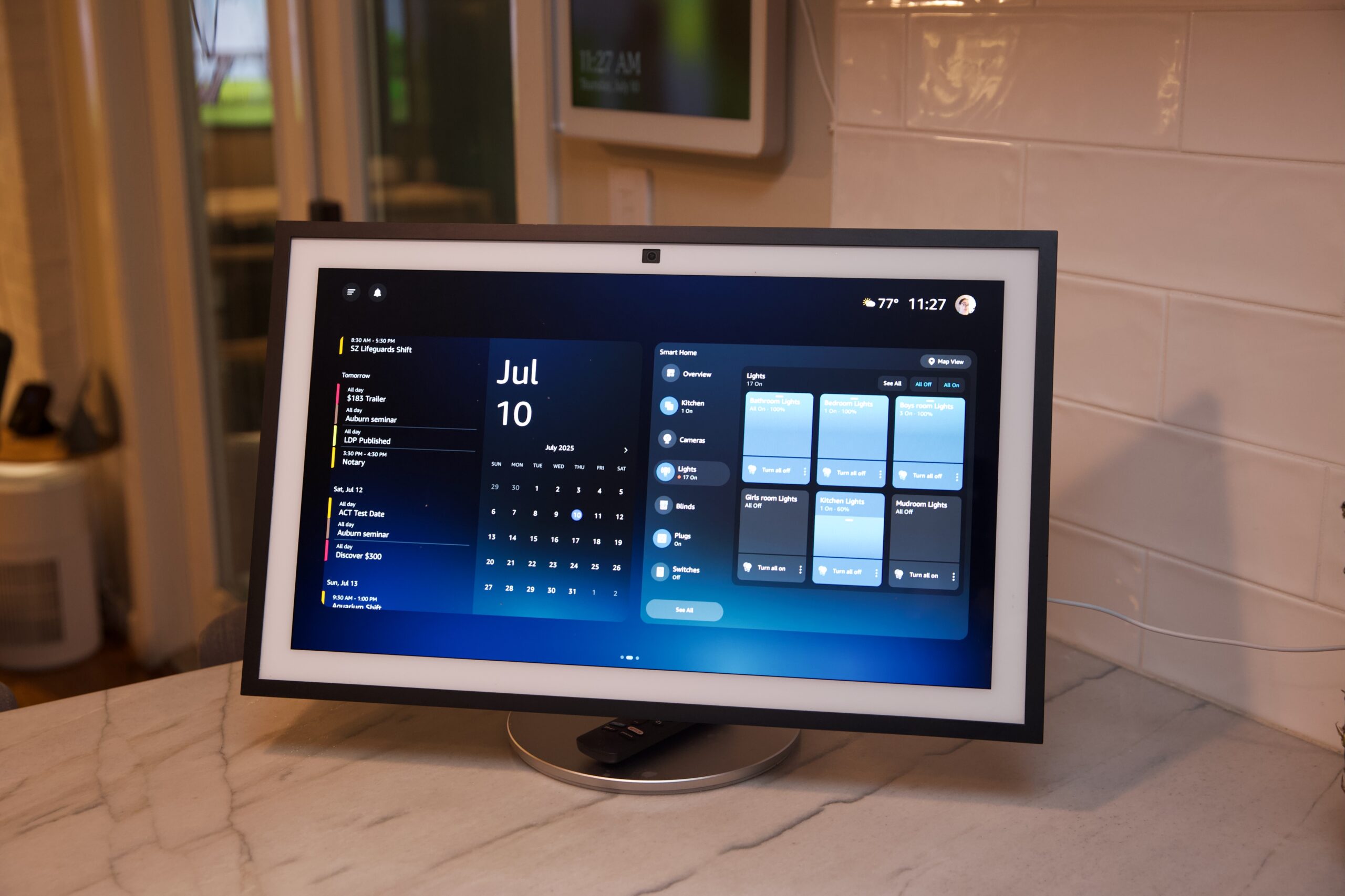 A large smart display on a kitchen counter showing smart home controls and a calendar. 