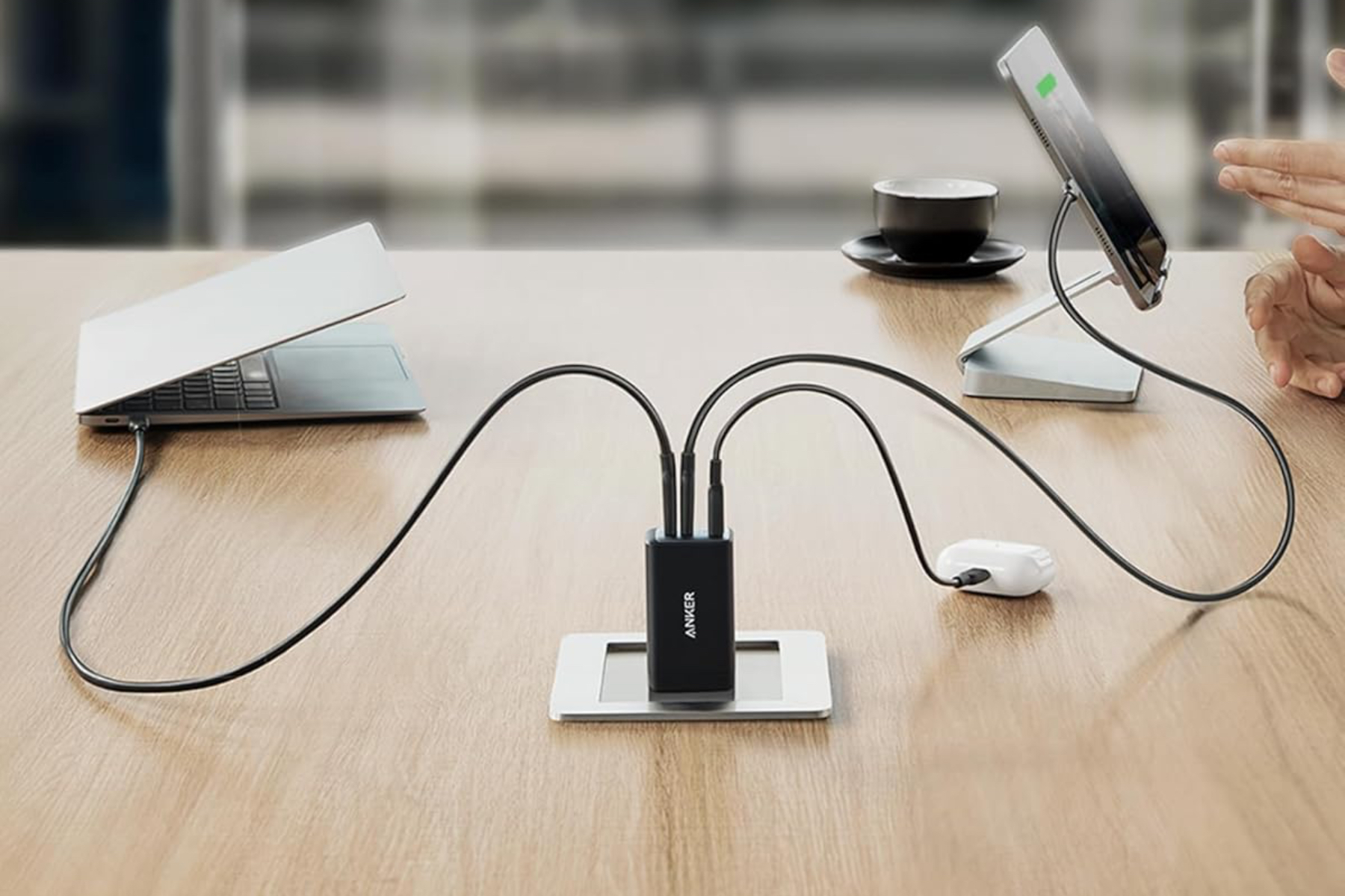An image of Anker’s 735 Charger plugged into a table outlet, with both a laptop and tablet plugged in.