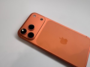 The iPhone 17 Pro in Cosmic Orange lying on a table.