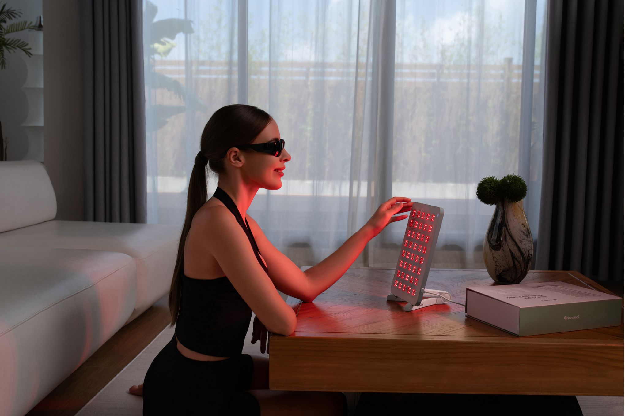 A woman using the Nanoleaf light therapy panel.